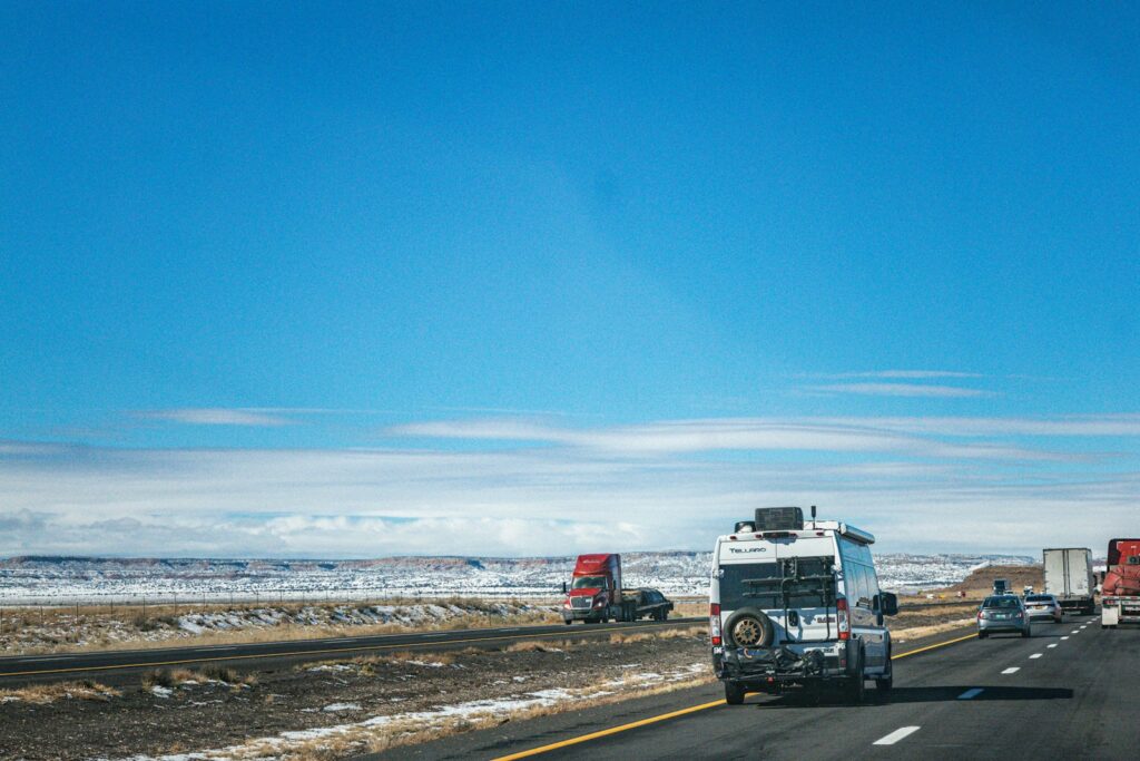 Trucks driving on a highway under a clear blue sky